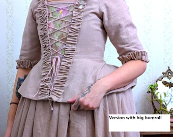 May include: A dusty rose linen dress with a fitted bodice and a full skirt. The bodice features a lace-up front with a floral embroidery design and a ruffle trim. The dress has a gathered skirt and a large bumroll.