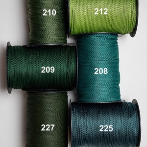 Puede incluir: Surtido de seis carretes de cordón de colores, cada uno con un tono diferente de verde. Los carretes están etiquetados con números: 210, 212, 209, 208, 227 y 225. El cordón parece ser de un material sintético liso.