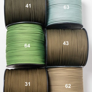 Può includere: Sei bobine di cordoncino in vari colori, tra cui verde, marrone e beige. Ogni bobina è etichettata con un numero: 41, 63, 64, 43, 31 e 62.