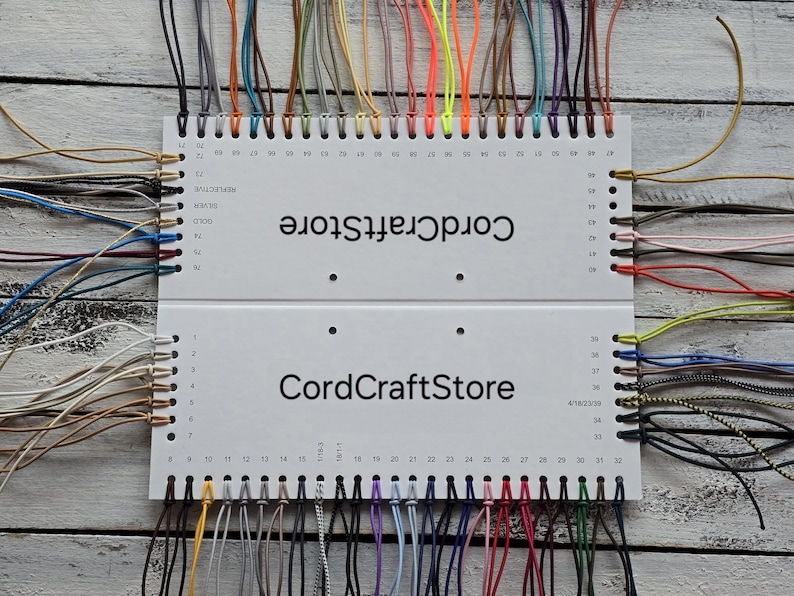 May include: A white rectangular display card labeled CordCraftStore featuring numerous holes along the edges, each holding a thin cord in a variety of colors including black, white, red, blue, yellow, green, brown, and metallic shades.