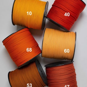 May include: Six spools of cord in various shades of orange, yellow, and red. The spools are labeled with numbers: 10, 40, 68, 60, 53, and 47.