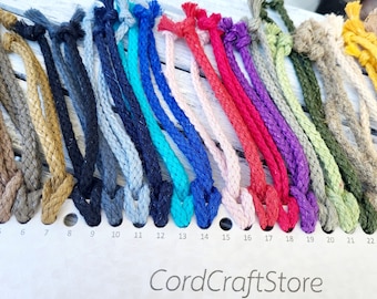 May include: A color chart of 24 different colors of cotton cord. The cords are arranged in a row from left to right, with the numbers 4 through 24 printed below each cord.