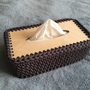 Könnte beinhalten: Eine weiße Keramik-Tasse mit schwarzem Henkel und dem Text "But First, Coffee" in schwarzer, handschriftlicher Schrift. Die Tasse steht auf einer weißen Oberfläche.