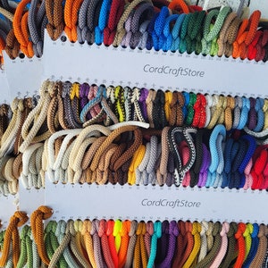 Peut inclure: Un nuancier de cordons de différentes couleurs, avec le texte "CordCraftStore" imprimé sur le nuancier. Les cordons sont disposés en rangées et en colonnes, et chaque cordon est étiqueté d'un numéro.