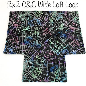 May include: Black fabric with a constellation design in neon colors. The fabric has a grid pattern and the text "2x2 C&C Wide Loft Loop" at the top. The design features zodiac symbols and stars.