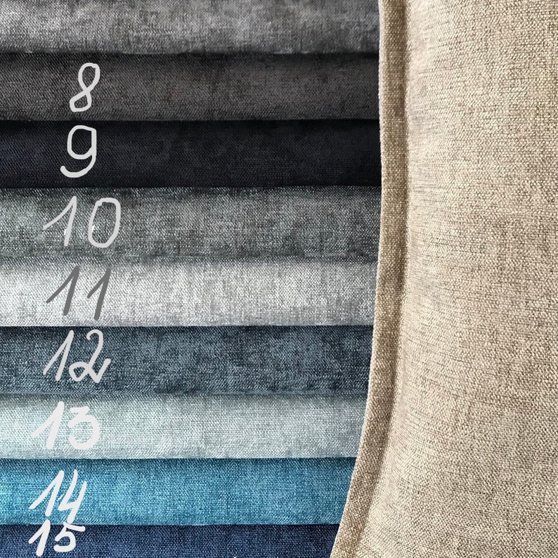 May include: A close-up of a fabric swatch book with 8 different fabric samples. The swatches are arranged in a vertical stack, with the darkest fabric at the top and the lightest fabric at the bottom. The fabric samples range in color from dark gray to light blue. The fabric swatches are numbered 8 through 15.