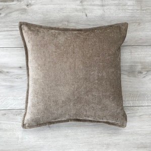 May include: A brown square throw pillow with a textured fabric.