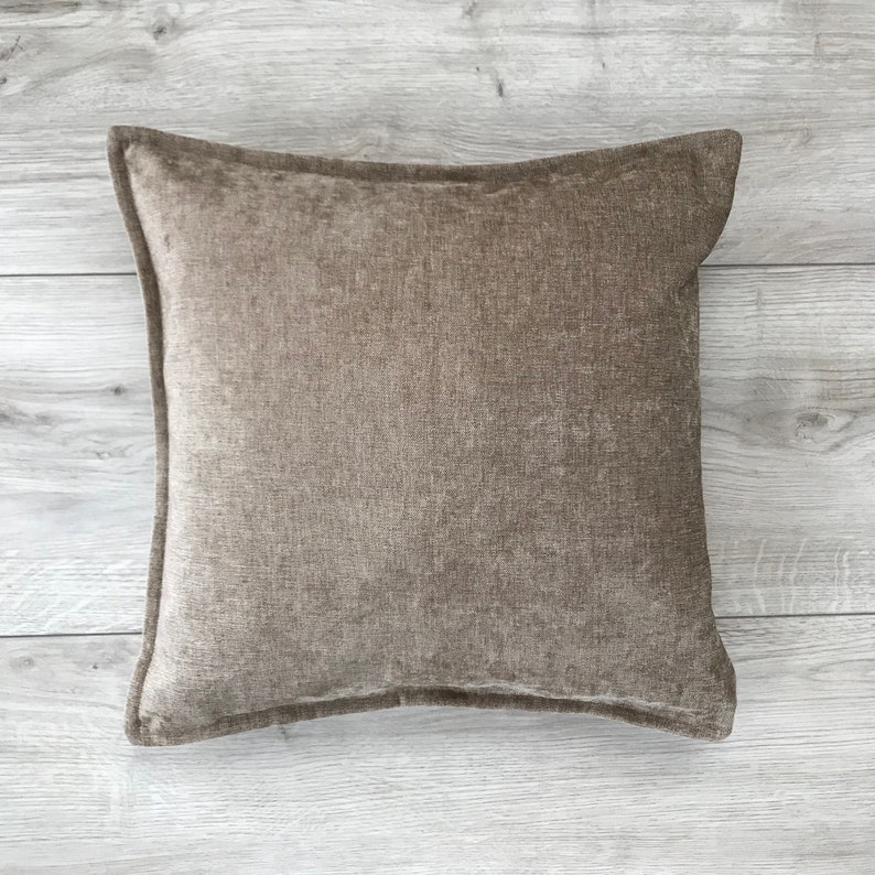 May include: A brown square throw pillow with a textured fabric.