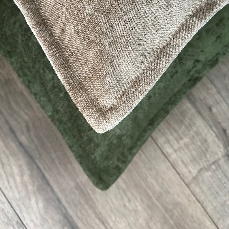 May include: Two fabric pillow covers, one in a light beige color and the other in a dark green color. The covers are made of a textured fabric and are shown overlapping each other.