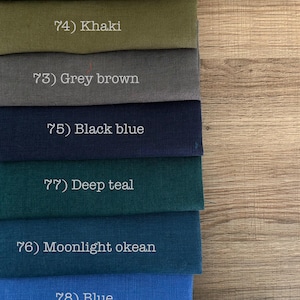 May include: A stack of seven fabric swatches in various colors, each labeled with a number and name: 26) Forest green, 74) Khaki, 73) Grey brown, 75) Black blue, 77) Deep teal, 76) Moonlight okean, and 78) Blue. The fabric has a visible weave.