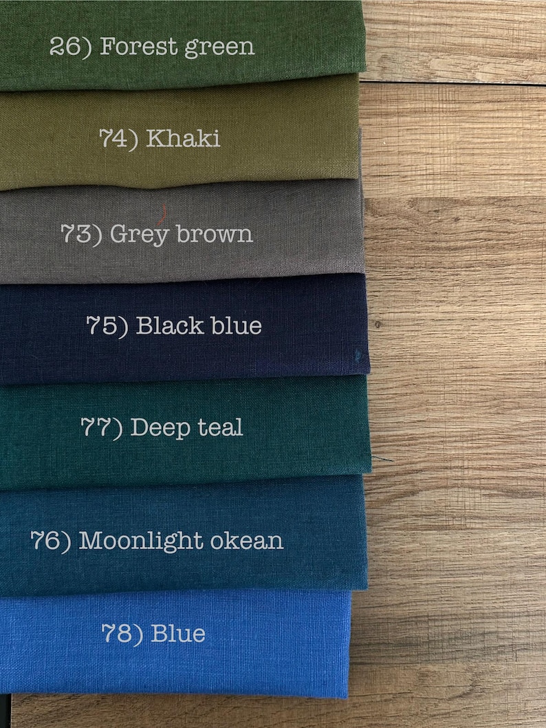 May include: A stack of seven fabric swatches in various colors, each labeled with a number and name: 26) Forest green, 74) Khaki, 73) Grey brown, 75) Black blue, 77) Deep teal, 76) Moonlight okean, and 78) Blue. The fabric has a visible weave.