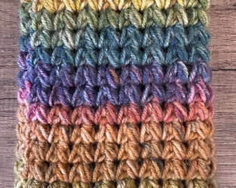 May include: A crocheted pouch with a rainbow color pattern and a silver button closure.