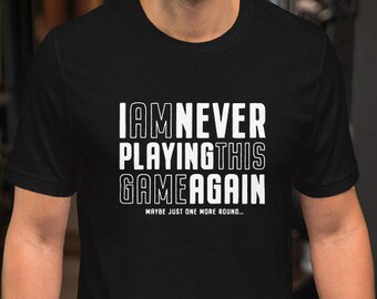 May include: Black t-shirt with white text that reads "I am never playing this game again. Maybe just one more round..."