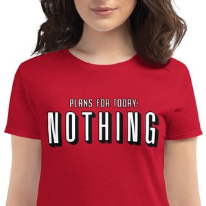 May include: Red women's t-shirt with short sleeves and a white graphic that says "Plans for today: NOTHING" in a black and white Netflix-style font.