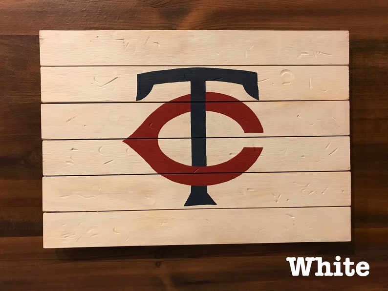 K&ouml;nnte beinhalten: Ein wei&szlig;es Holzschild mit einem roten und blauen "C" und "T" Logo. Das Schild besteht aus mehreren Holzbrettern und hat einen abgenutzten Look.