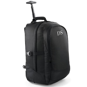 May include: A black rolling backpack with a retractable handle and wheels. The backpack features a padded back and straps, a front pocket, and a buckle closure. The initials "DS" are printed in white on the front.