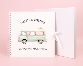 May include: A white spiral bound photo album with a colorful illustration of a camper van and the text "Maisie & Colin's Campervan Adventures".