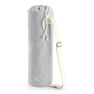 May include: A gray canvas yoga mat bag with a white drawstring and a white adjustable strap. The bag has the initials "EL" embroidered on the front.