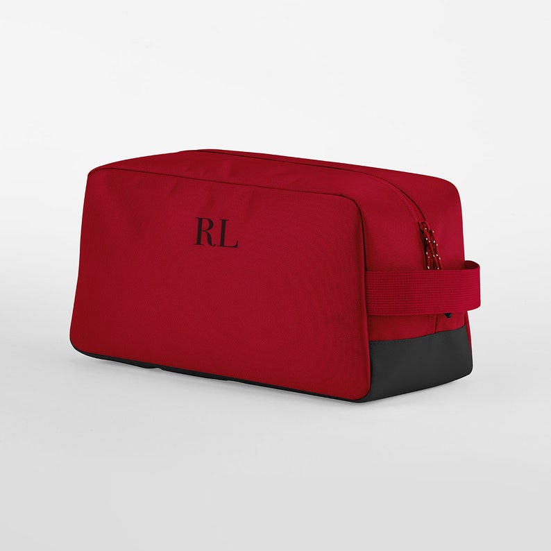 May include: Red travel bag with a black zipper and a black handle. The bag has the initials "RL" embroidered on the front.