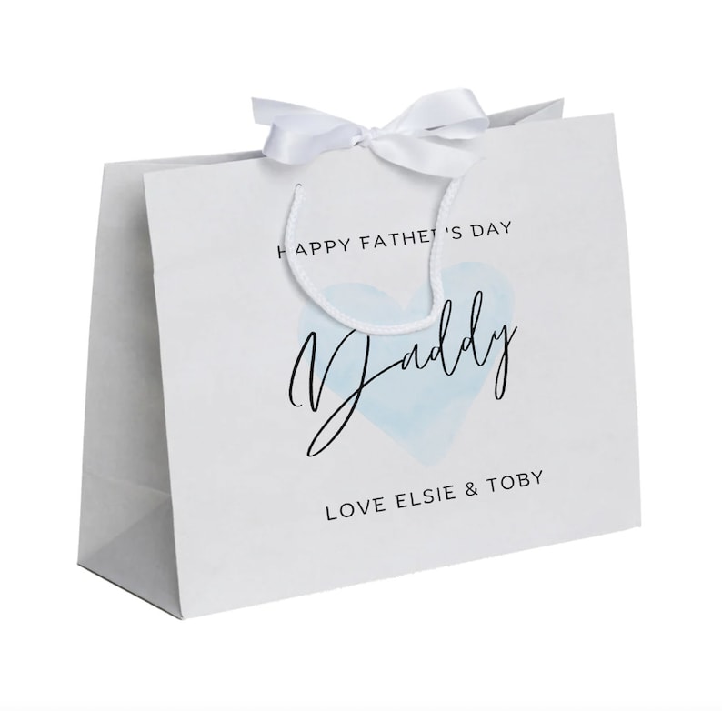May include: White gift bag with a blue watercolor heart and the text "Happy Father's Day Daddy Love Elsie & Toby"