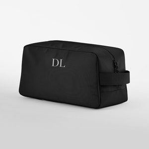 May include: Black wash bag with a zip fastening and a handle. The bag has the initials "DL" embroidered on the front.