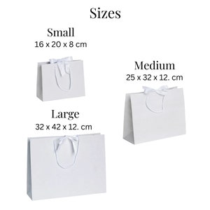 May include: Three white gift bags with white satin ribbon bows and handles. The bags are labeled "Small" (16 x 20 x 8 cm), "Medium" (25 x 32 x 12 cm), and "Large" (32 x 42 x 12 cm).