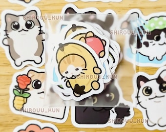 May include: A collection of die-cut vinyl stickers featuring cartoon cats in various poses and costumes, including a cat inside a banana peel, a cat holding a red rose, and a cat wearing a lion mane, all with the text SHIROUU_KUN printed on them.