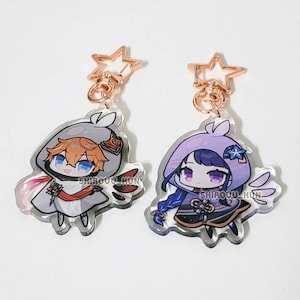 May include: Two acrylic charms featuring chibi-style anime characters with star-shaped rose gold clasps. The left charm depicts a character with orange hair in a grey hood, while the right charm shows a character with purple hair in a purple hood.