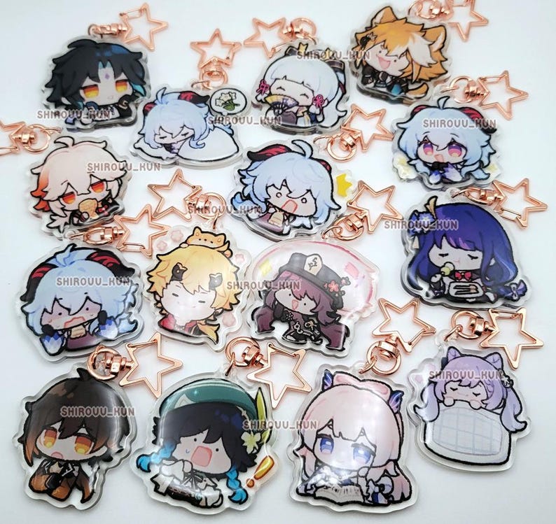 Puede incluir: Una colecci&oacute;n de llaveros de acr&iacute;lico transparente con varios personajes de anime estilo chibi con atuendos y expresiones coloridas. Cada dije est&aacute; unido a un broche de metal en forma de estrella de color oro rosa. El texto SHIROUU_KUN est&aacute; impreso.
