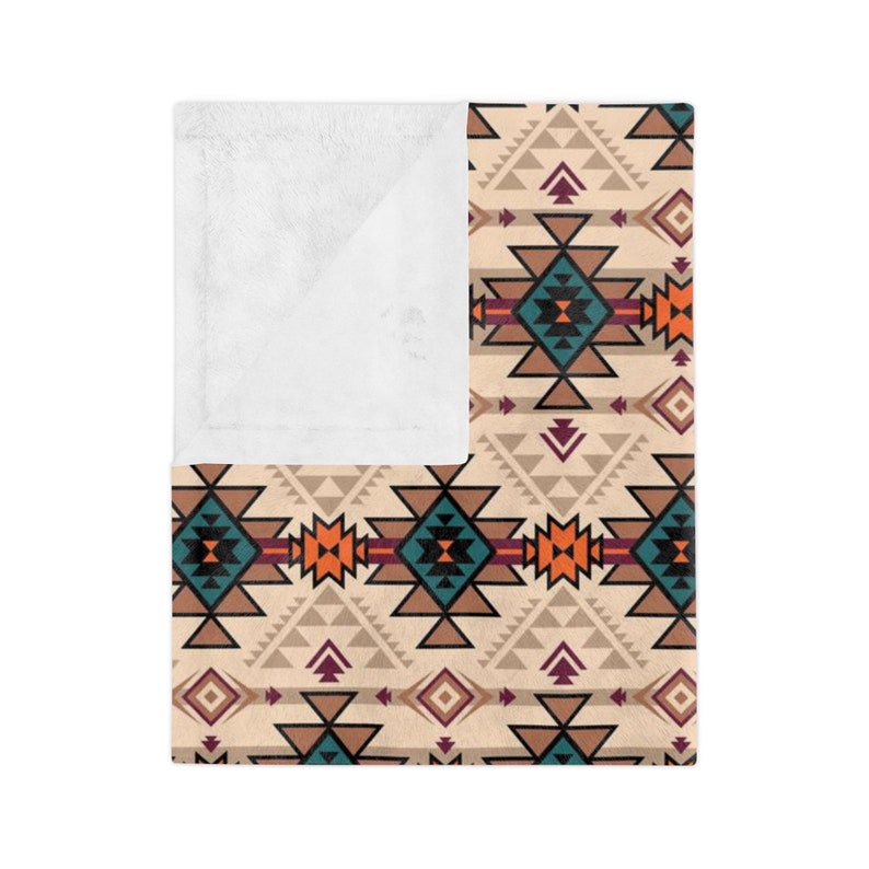 K&ouml;nnte beinhalten: Eine weiche, pl&uuml;schige Kuscheldecke mit einem geometrischen Muster in Braun-, Orange-, T&uuml;rkis- und Burgunder-T&ouml;nen. Das Muster erinnert an indianische Designs.