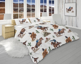 Puede incluir: Bedding blanco con un patrón repetido de vaqueros montando caballos. Los caballos son marrones y los vaqueros llevan camisas azules y pantalones vaqueros. El fondo es blanco con plantas de cactus verdes.