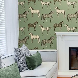 May include: A green wallpaper with a repeating pattern of black and white horses. The wallpaper is in a living room setting with a white couch and green pillows.
