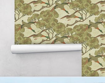 May include: A wallpaper design featuring a repeating pattern of green trees and flying ducks. The ducks are depicted in a stylized, almost cartoonish manner, with brown bodies, green wings, and orange beaks. The trees are a deep green, with brown branches and leaves. The background is a light beige.