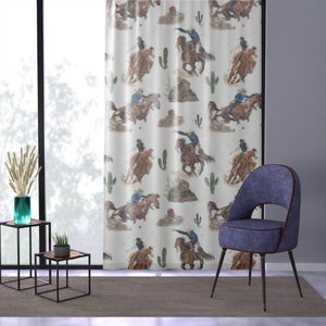 May include: White curtain panel featuring a repeating watercolor pattern of cowboys riding horses, cacti, and small rock formations. The curtain is hanging in front of a window, with a modern chair and side tables in the room.