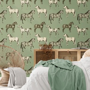 May include: A green wallpaper with a repeating pattern of black and white horses. The wallpaper is in a bedroom setting with a bed and a chair.