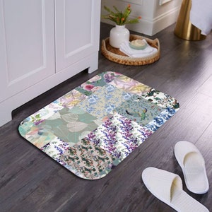 May include: A rectangular patchwork floor mat with a variety of floral and leaf patterns in shades of green, blue, pink, and purple. The mat has a slightly rounded edge.