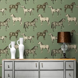 May include: A vintage-style dresser with a light gray finish and wooden accents. The dresser has six drawers and is set against a green wallpaper with a repeating pattern of black and white horses.