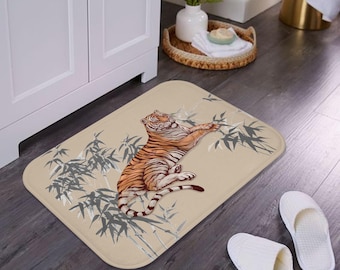 May include: A beige bath mat with a tiger and bamboo design. The tiger is orange and black with white stripes. The bamboo is gray and white.