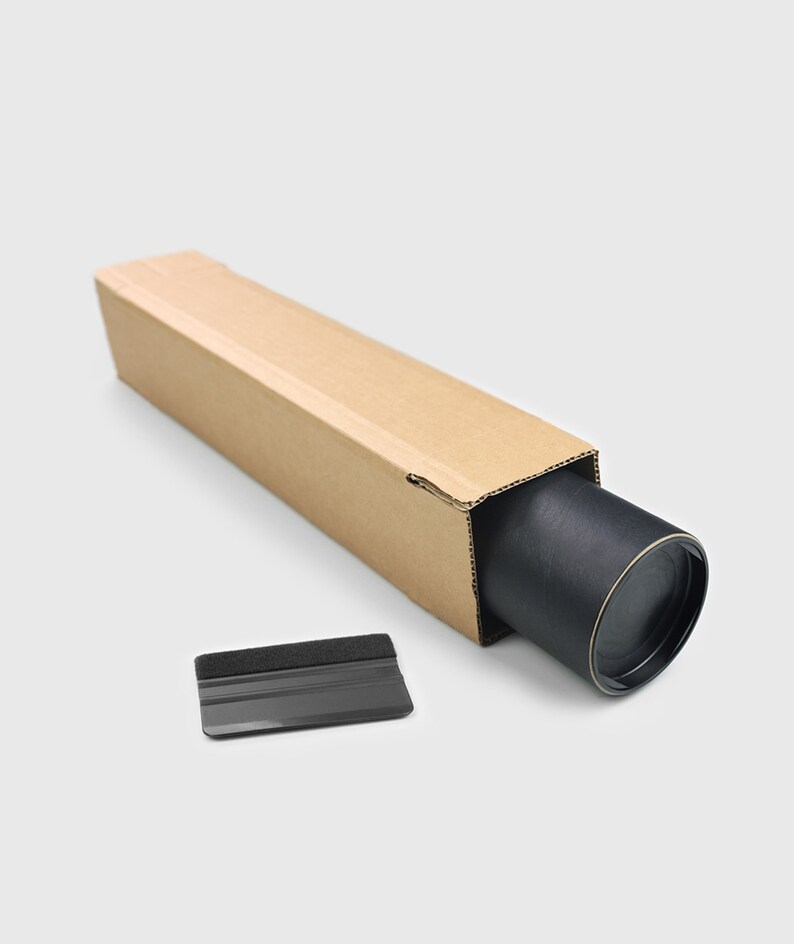 May include: A brown cardboard tube with a black roll inside. A black plastic squeegee with a gray foam edge is next to the tube.