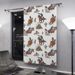 May include: White curtain panel featuring a repeating watercolor pattern of cowboys on horseback, cacti, and desert elements. The cowboys are depicted in blue and brown tones, with the horses in shades of brown. The design has a Western theme.