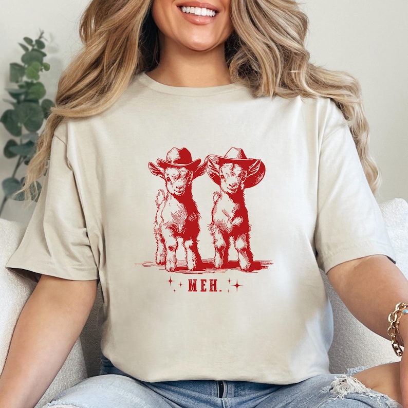 a woman sitting on a couch wearing a t - shirt with a picture of two