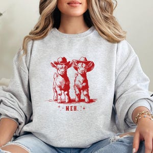 a woman sitting on a couch wearing a sweatshirt