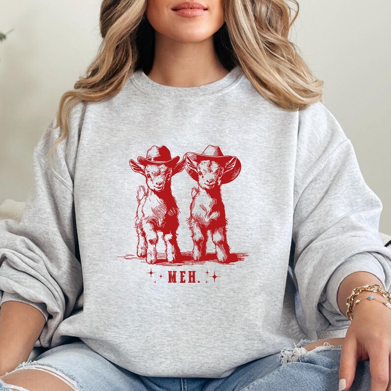 a woman sitting on a couch wearing a sweatshirt