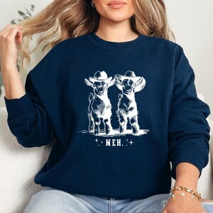 a woman sitting on a couch wearing a sweatshirt