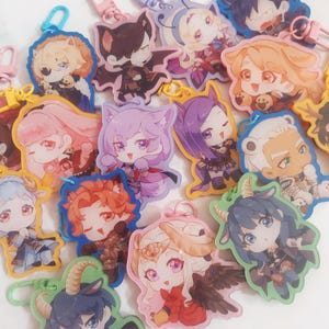 May include: A selection of vibrant acrylic keyrings showcasing anime-style character designs. Each keyring features a unique character with animal-like traits, like cat ears or horns, and is attached to a metal clasp.