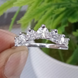 May include: A silver ring with a crown-shaped band of small, clear diamonds.