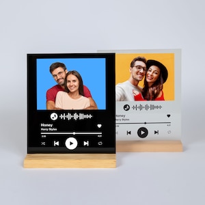 May include: Two photo displays featuring a couple, with a music waveform graphic and song details. One is black with a blue background, the other is clear with a yellow background. Both are mounted on wooden bases.