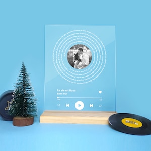 May include: A clear acrylic plaque with a black and white photo of a couple, surrounded by a circular text design. The plaque features the song title "La vie en Rose" and artist Edith Piaf, with a music player interface.