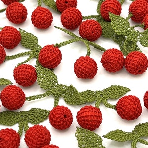 May include: A string of crocheted red cherries with green leaves. The cherries are made of a fine, delicate yarn and have a realistic appearance.