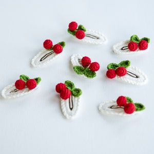 Puede incluir: Ocho pinzas para el pelo de crochet blanco con cerezas de crochet rojo y verde.